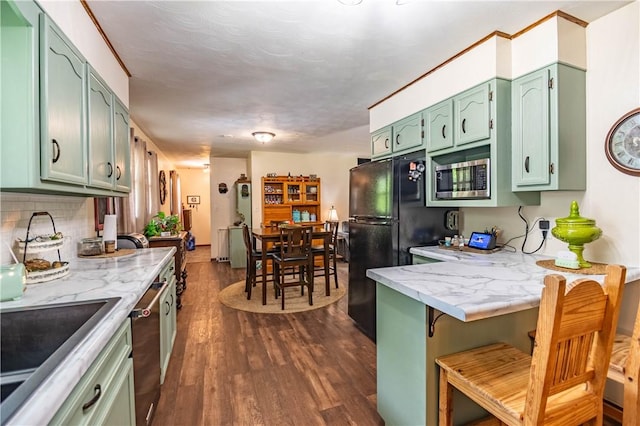 37 Ohio Dr, Decatur, IL 62526 - kitchen with green cabinets, appliances with stainless steel finishes, a peninsula, dark wood-type flooring, and tasteful backsplash