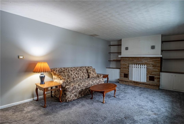 carpeted living room featuring radiator, a fireplace, and a textured ceiling