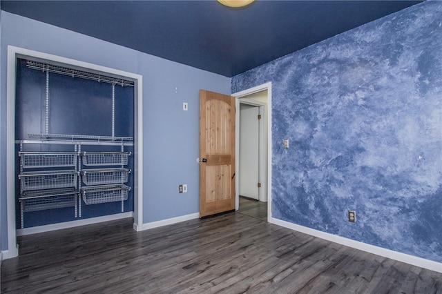 unfurnished bedroom featuring dark hardwood / wood-style flooring and a closet