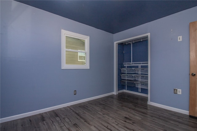 spare room featuring dark wood-type flooring