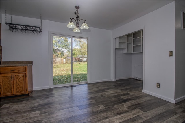 unfurnished dining area with a notable chandelier and dark hardwood / wood-style floors