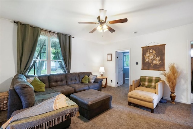 living room with baseboards, a ceiling fan, and carpet flooring