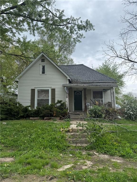 bungalow-style home with a shingled roof and a porch