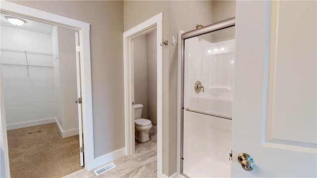 3006 E Stillwater Lndg, Urbana, IL 61802 - bathroom with a shower stall, toilet, a spacious closet, and baseboards