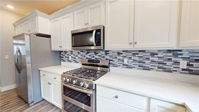 3006 E Stillwater Lndg, Urbana, IL 61802 - kitchen with appliances with stainless steel finishes, light countertops, light wood-type flooring, tasteful backsplash, and white cabinets