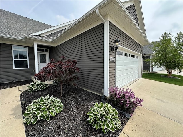 3006 E Stillwater Lndg, Urbana, IL 61802 - view of side of home with concrete driveway, a garage, and roof with shingles