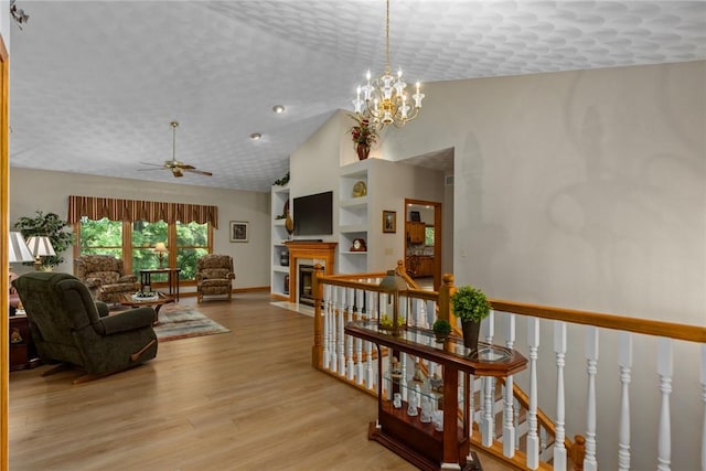 8434 Meadowview Rd, Effingham, IL 62401 - living area with vaulted ceiling, light wood finished floors, a ceiling fan, built in shelves, and a fireplace