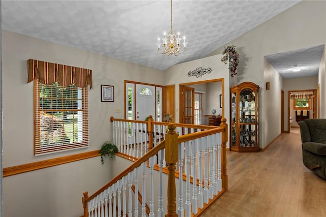 8434 Meadowview Rd, Effingham, IL 62401 - hallway featuring an upstairs landing, a chandelier, wood-type flooring, and plenty of natural light