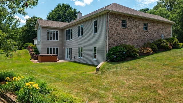 8434 Meadowview Rd, Effingham, IL 62401 - rear view of house featuring a hot tub, a chimney, a lawn, brick siding, and a patio area
