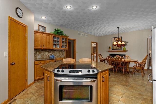 8434 Meadowview Rd, Effingham, IL 62401 - kitchen featuring stainless steel electric range oven, brown cabinets, a center island, tasteful backsplash, and a chandelier
