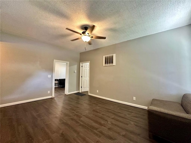 705 S 16th St, Mattoon, IL 61938 - unfurnished living room with ceiling fan, dark wood-type flooring, and a textured ceiling