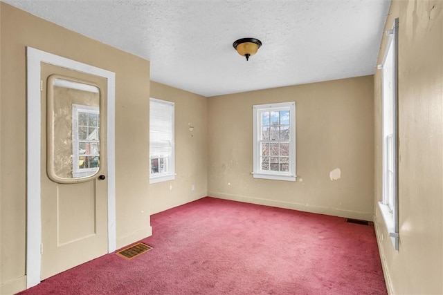 carpeted entryway with baseboards, visible vents, and a textured ceiling