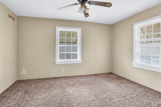 carpeted spare room with ceiling fan, baseboards, and a textured ceiling