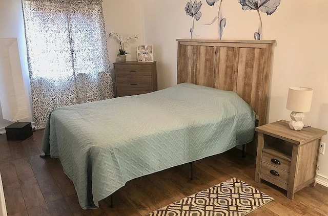 bedroom featuring hardwood / wood-style floors and baseboards