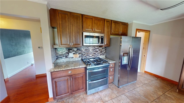 204 Bryan St, Catlin, IL 61817 - kitchen featuring appliances with stainless steel finishes, tasteful backsplash, crown molding, baseboards, and light stone counters