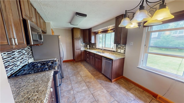 204 Bryan St, Catlin, IL 61817 - kitchen with appliances with stainless steel finishes, baseboards, a sink, decorative backsplash, and light stone countertops