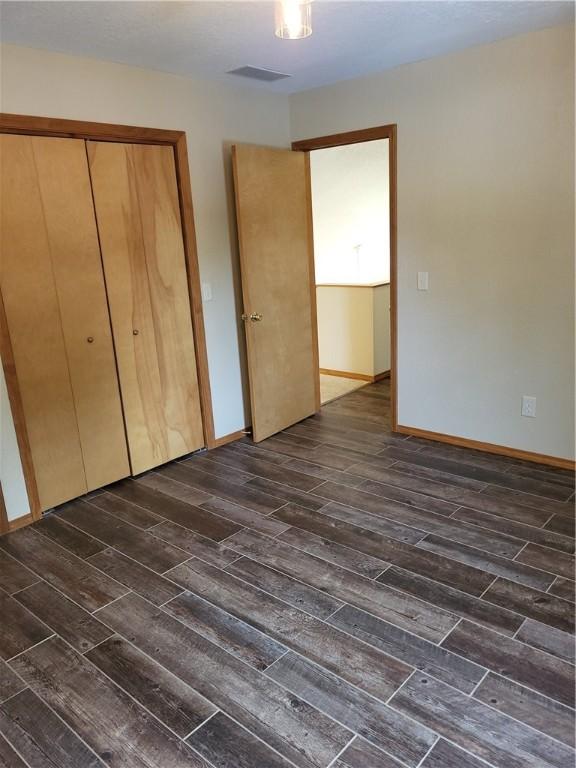107 Edgewood Ave, Effingham, IL 62401 - unfurnished bedroom featuring dark wood finished floors and a closet