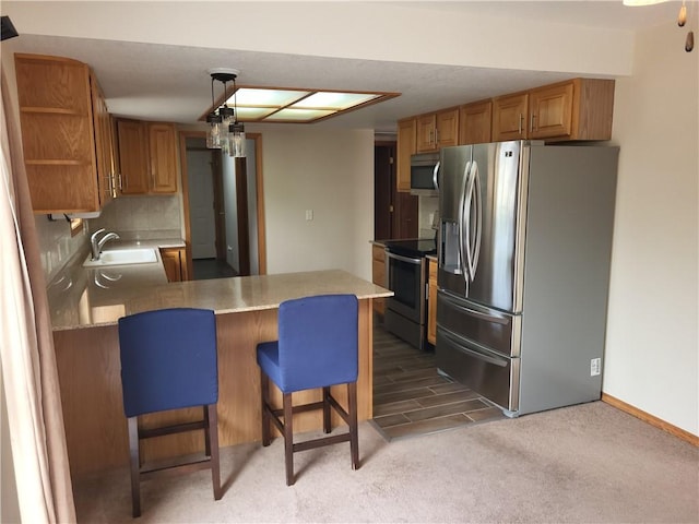 107 Edgewood Ave, Effingham, IL 62401 - kitchen with appliances with stainless steel finishes, a peninsula, open shelves, light colored carpet, and a kitchen breakfast bar