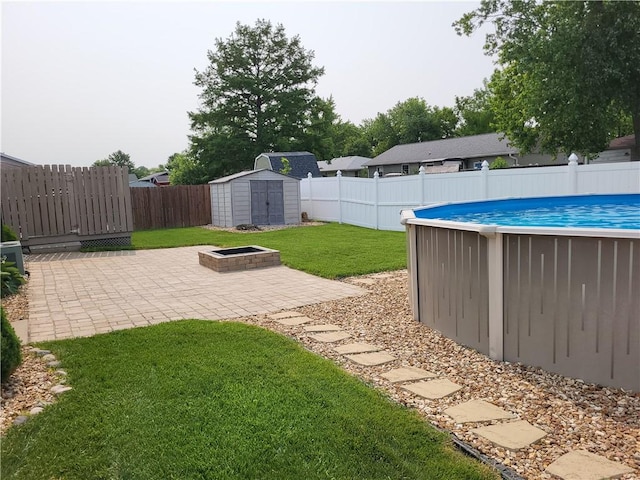 107 Edgewood Ave, Effingham, IL 62401 - fenced backyard with a shed, a patio area, and a fire pit