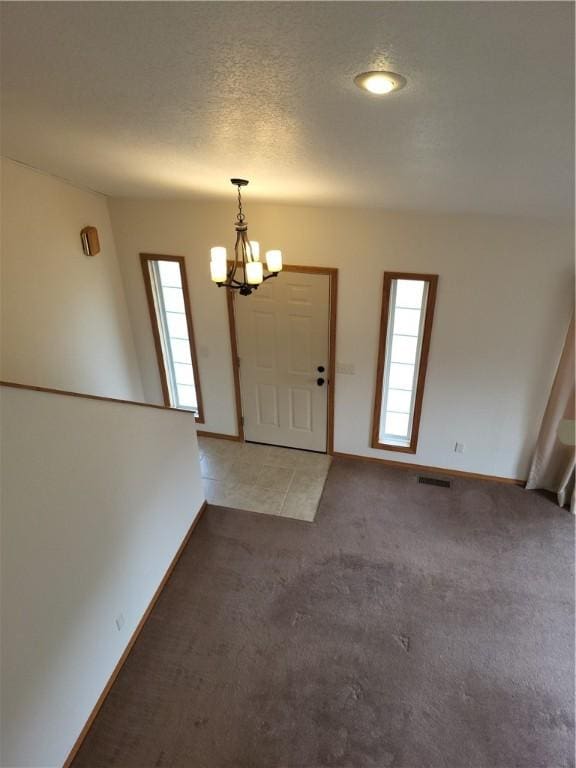 107 Edgewood Ave, Effingham, IL 62401 - entryway with a chandelier, light colored carpet, and a textured ceiling