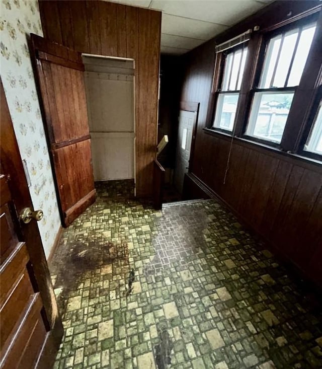 316 Plum St, Danville, IL 61832 - unfurnished bedroom with brick patterned floors, wallpapered walls, and wooden walls