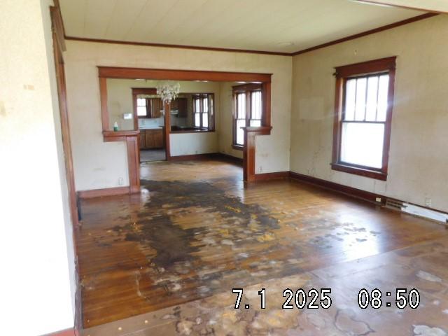 316 Plum St, Danville, IL 61832 - unfurnished living room with ornamental molding, wood finished floors, and a chandelier