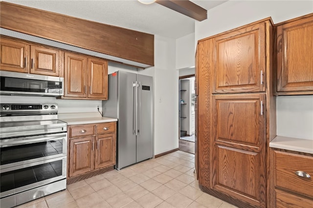 3044 Greenlake Dr, Decatur, IL 62521 - kitchen featuring appliances with stainless steel finishes, brown cabinetry, light countertops, and light tile patterned floors