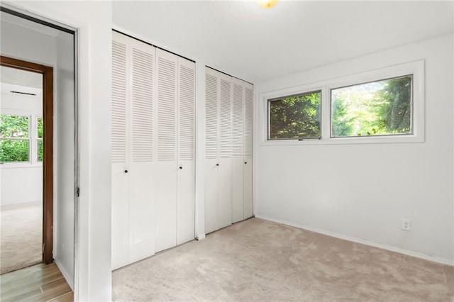 3044 Greenlake Dr, Decatur, IL 62521 - unfurnished bedroom featuring multiple closets and light carpet