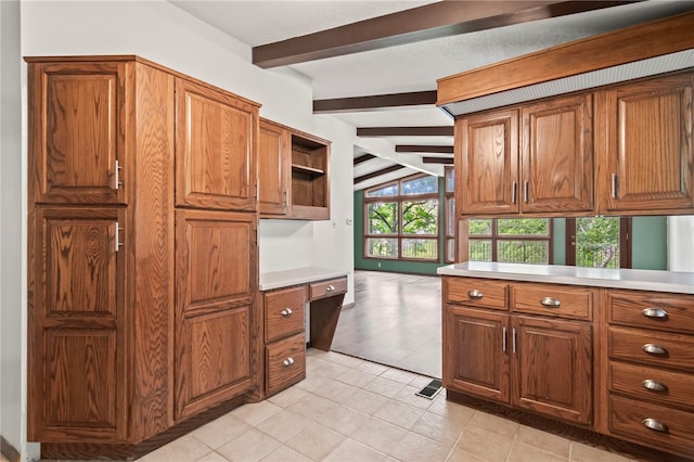 3044 Greenlake Dr, Decatur, IL 62521 - kitchen with brown cabinets, built in study area, light countertops, light tile patterned flooring, and open shelves