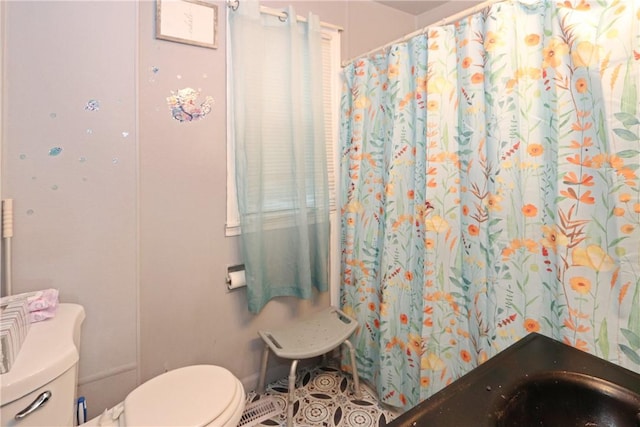 bathroom with toilet and curtained shower