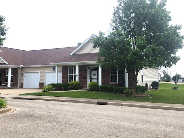 8 Courtyard Blvd, Sullivan, IL 61951 - ranch-style house featuring an attached garage, brick siding, a front lawn, cooling unit, and concrete driveway