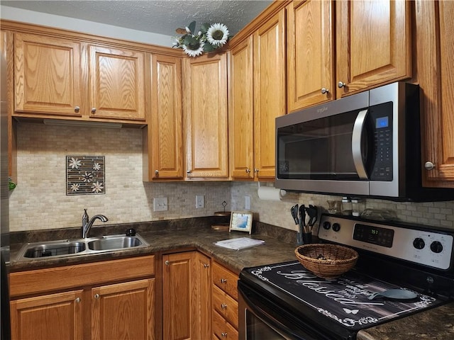 8 Courtyard Blvd, Sullivan, IL 61951 - kitchen featuring appliances with stainless steel finishes, a sink, dark countertops, backsplash, and a textured ceiling