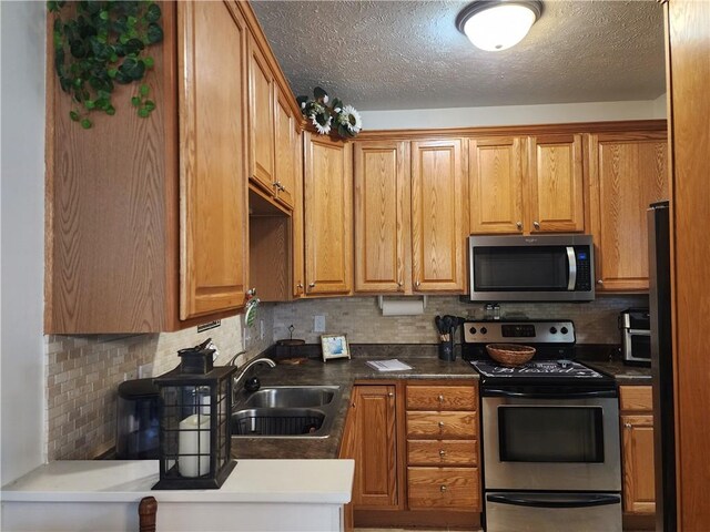 8 Courtyard Blvd, Sullivan, IL 61951 - kitchen with stainless steel appliances, a sink, decorative backsplash, brown cabinetry, and a textured ceiling