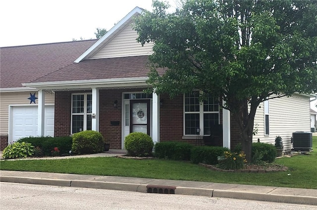8 Courtyard Blvd, Sullivan, IL 61951 - view of front of property with brick siding, a front yard, central AC unit, an attached garage, and a shingled roof