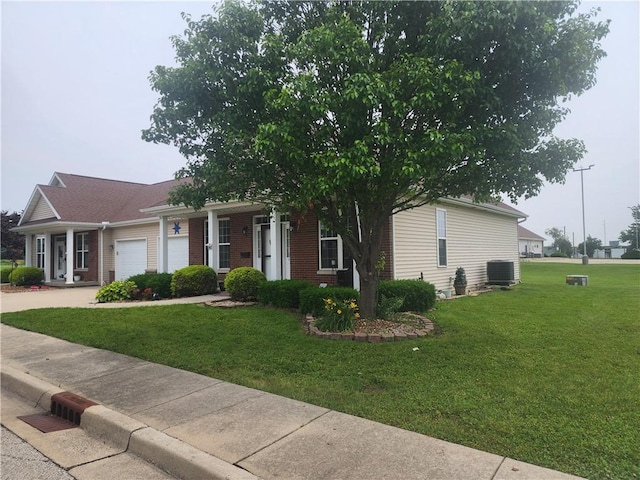 8 Courtyard Blvd, Sullivan, IL 61951 - view of front of house featuring a garage, cooling unit, a front lawn, driveway, and brick siding