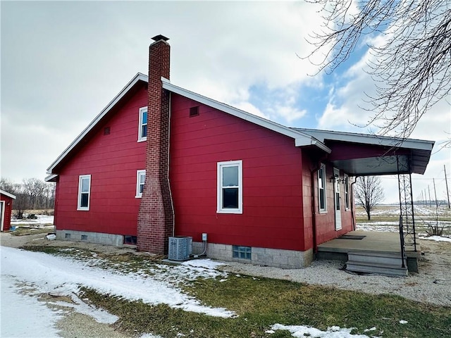 snow covered property with central air condition unit