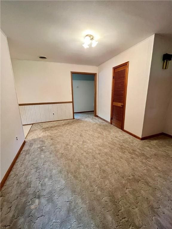 spare room with baseboards and carpet floors