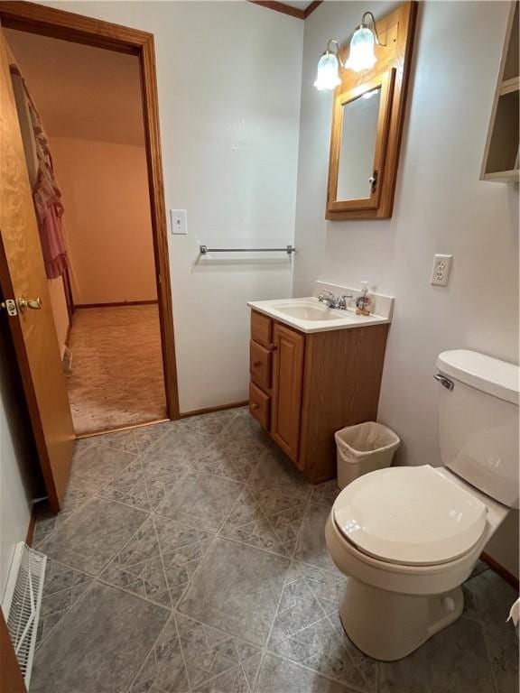 half bathroom featuring toilet, tile patterned flooring, and vanity