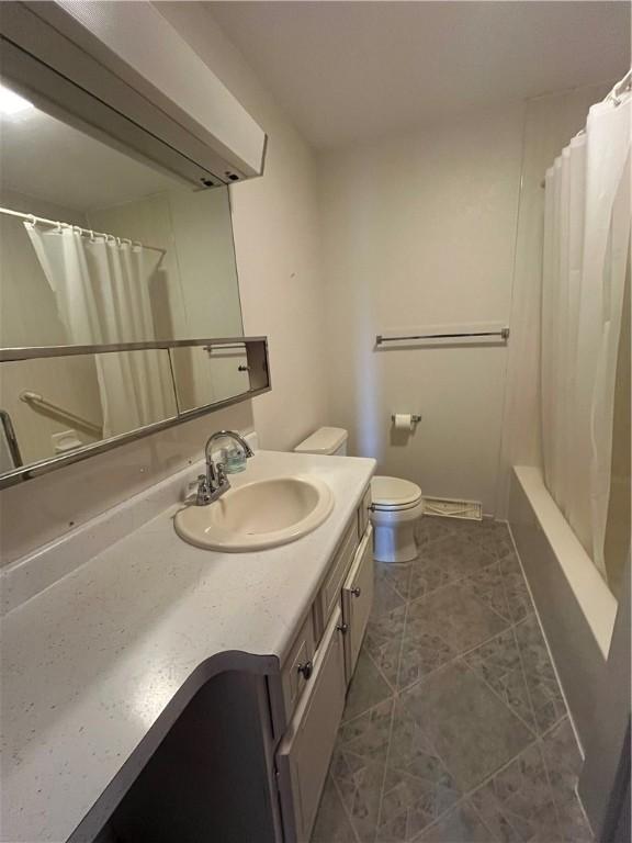 full bath with toilet, tile patterned flooring, and vanity