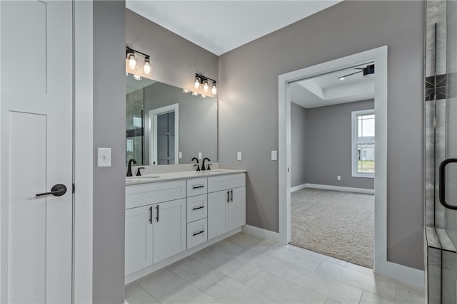 bathroom featuring tile patterned flooring, vanity, and a raised ceiling