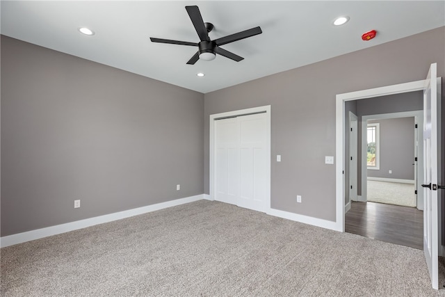 unfurnished bedroom with a closet, dark carpet, and ceiling fan