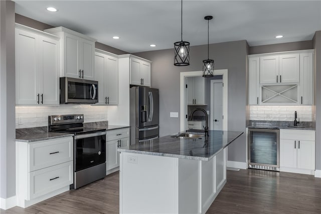 kitchen with sink, white cabinets, beverage cooler, and appliances with stainless steel finishes