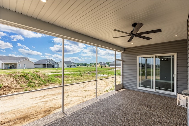 unfurnished sunroom with ceiling fan