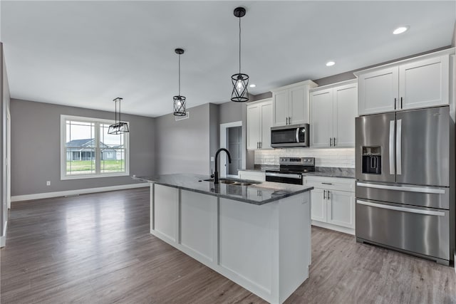 kitchen featuring white cabinets, sink, an island with sink, light hardwood / wood-style floors, and stainless steel appliances