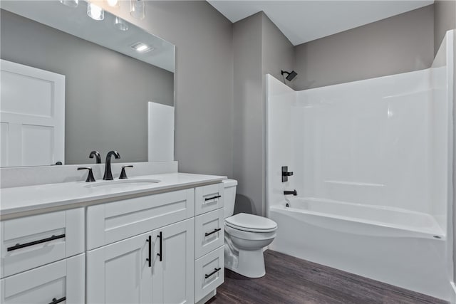 full bathroom with bathtub / shower combination, wood-type flooring, vanity, and toilet