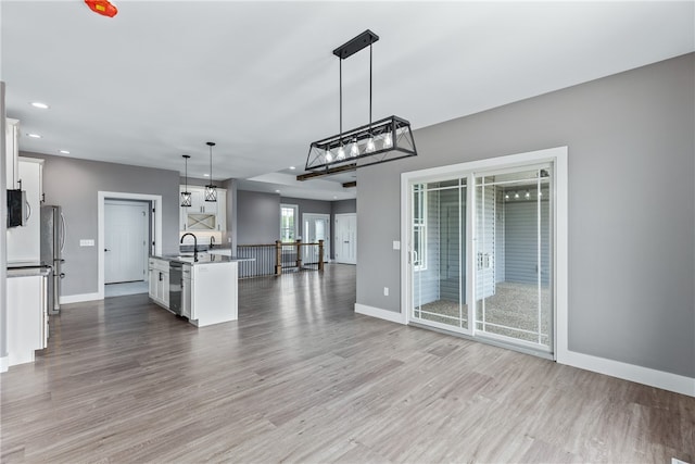 unfurnished living room with sink and light hardwood / wood-style flooring