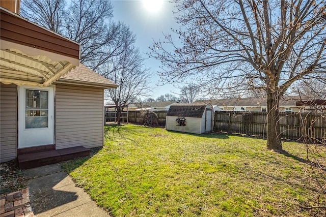 view of yard with a fenced backyard, a shed, and an outdoor structure