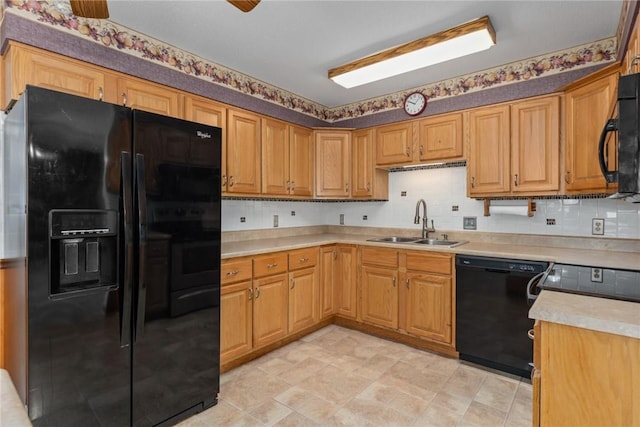 kitchen featuring decorative backsplash, black appliances, light countertops, and a sink