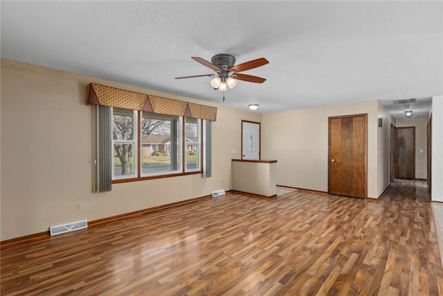 unfurnished living room featuring visible vents, baseboards, wood finished floors, and a ceiling fan