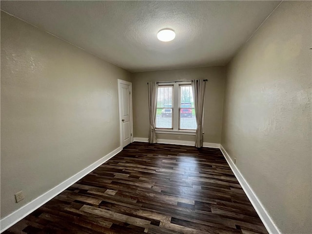 605 N 15th St, Mattoon, IL 61938 - unfurnished room featuring dark wood-type flooring, a textured ceiling, and baseboards